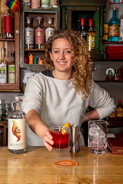 A bartender holding out a cocktail
