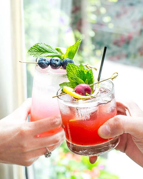 Two glasses being clinked together in a toast.